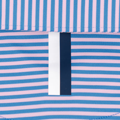 Close-up of RHOBACK’s The Birdie Stripe Performance Polo in Birdie Blue/Lotus Pink, showing four-way stretch fabric with blue and pink stripes, central vertical tag, and bottom seam for comfort and easy movement.