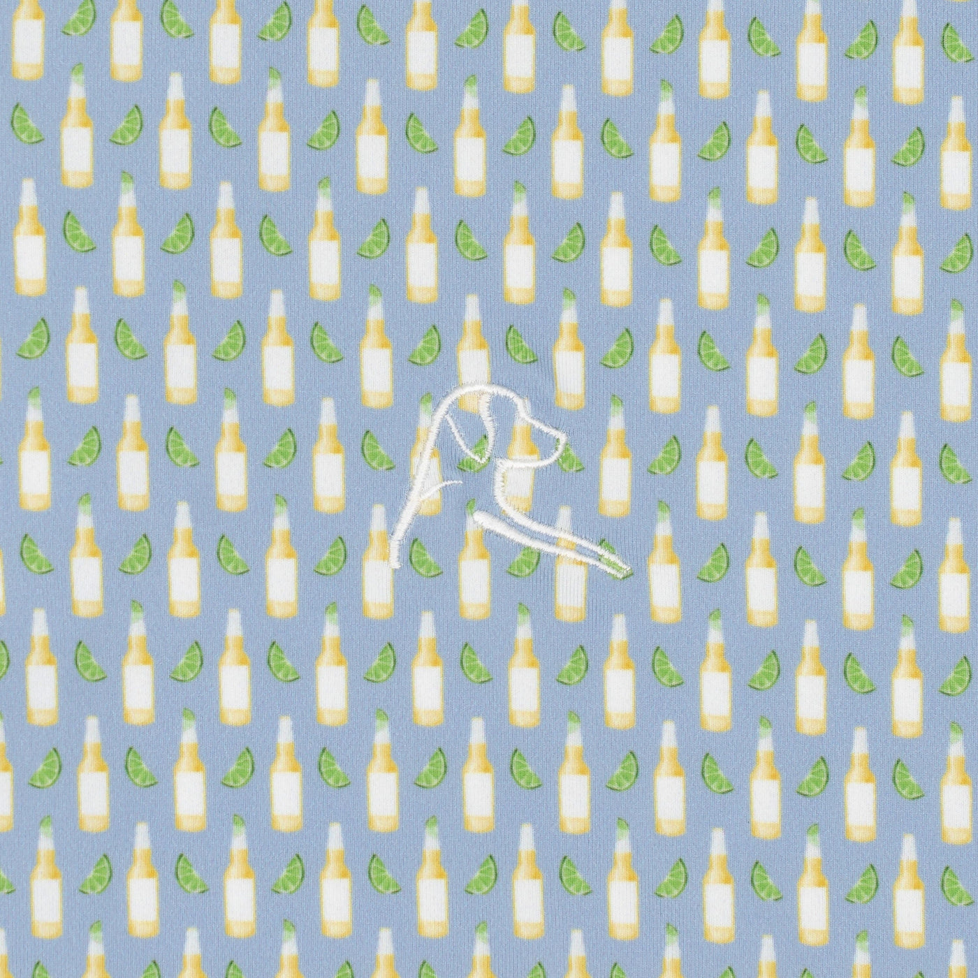 The RHOBACK The Cerveza Performance Polo features a pattern of yellow beer bottles and green lime wedges on oxford blue, with a white stitched dog head outline. Made from moisture-wicking fabric to keep you cool and comfortable all day.