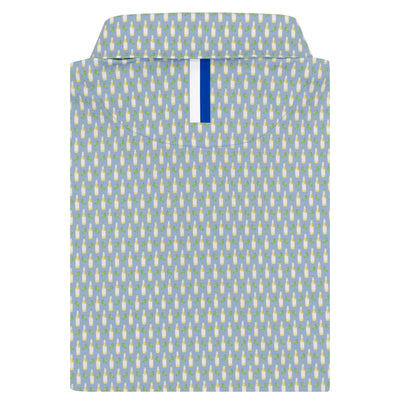 The RHOBACK Cerveza Performance Polo in Oxford Blue is neatly folded, featuring a repeating pattern of small yellow and white penguins, with a blue and white tag visible inside the collar.