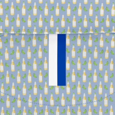 The RHOBACK The Cerveza Performance Polo in Oxford Blue features light blue, moisture-wicking fabric with a repeating beer bottle and lime pattern, plus a white and blue vertical stripe for stylish performance.
