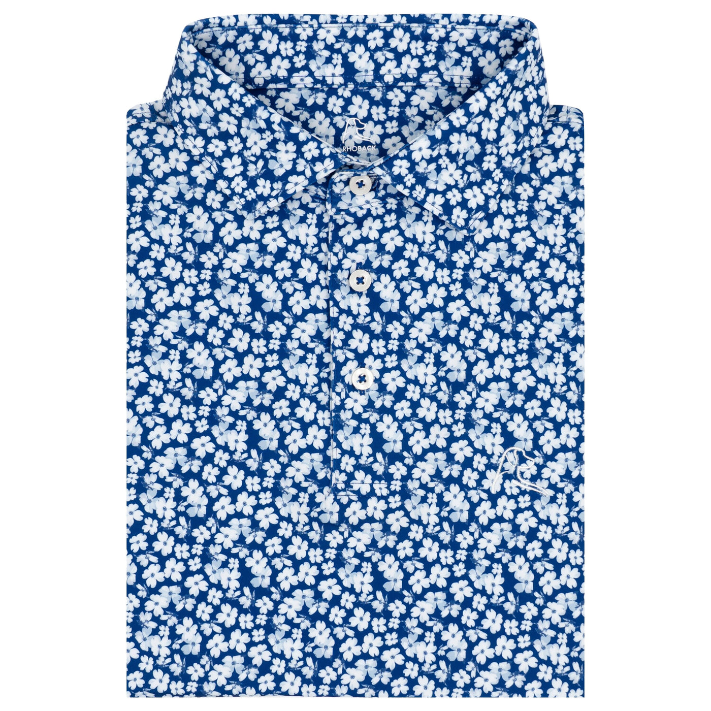 A neatly folded RHOBACK The Dogwood 2.0 Performance Polo in Shoal Blue/White, featuring a white floral pattern and white buttons, made from moisture-wicking fabric, displayed on a plain white background.