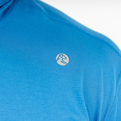 Close-up of the RHOBACK Blitz Tech Hoodie in Birdie Blue/Sapphire Blue, showcasing a small white circular abstract logo on the chest. Crafted from moisture-wicking SilverKnit fabric for superior comfort and performance.