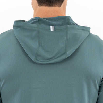 A person is shown from the back wearing the RHOBACK Blitz Tech Hoodie | Heather - Jungle Green/Dusty Pine. The hood is up but not covering the head, featuring a small reflective strip on the back. The background is white.