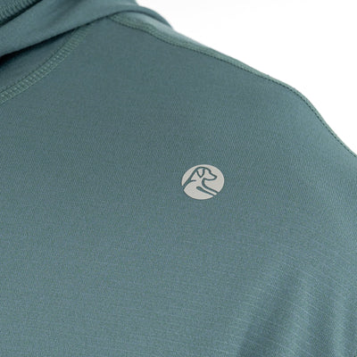 Close-up of the RHOBACK Blitz Tech Hoodie | Heather in Jungle Green/Dusty Pine, crafted from SilverKnit fabric and featuring a small, circular mountain and river logo near the shoulder.