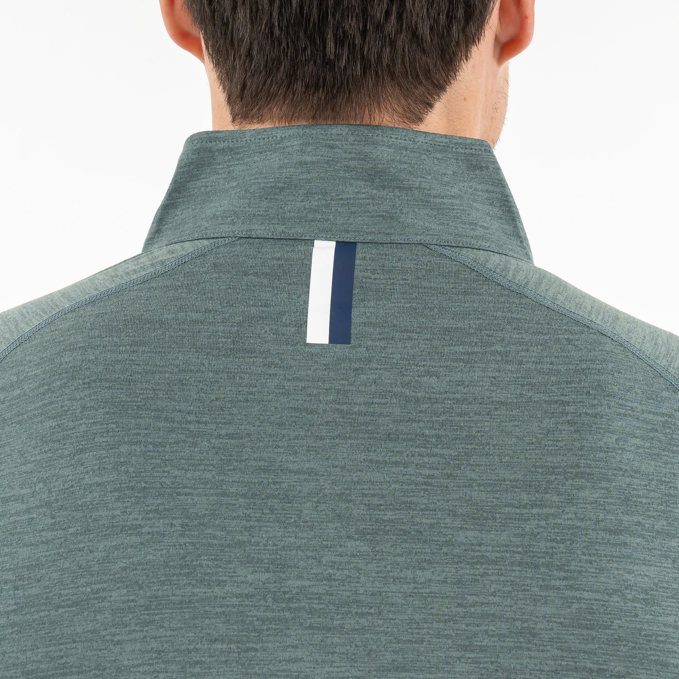 A person with a short dark haircut is seen from behind, wearing the RHOBACK Tailwind Performance Q-Zip in Heather - Jungle Green/Dusty Pine, featuring a high collar and a vertical white and navy stripe below the collar.