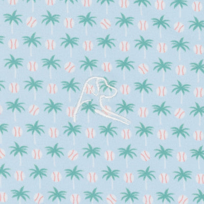 The Lil' Spring Ball Performance Polo by RHOBACK features a pale blue color with green palm trees and white baseballs, plus a white embroidered dog head. Enjoy sun protection and playful style all day.