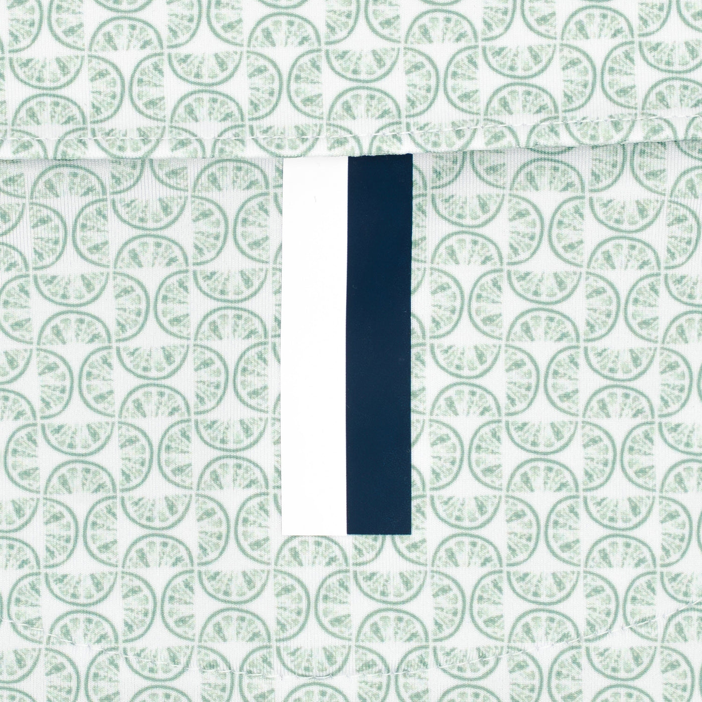 The Lime | Performance Polo by RHOBACK features a patterned surface with repeating green circles and a center vertical strip—white on the left, dark blue on the right—for a crisp, moisture-wicking finish.