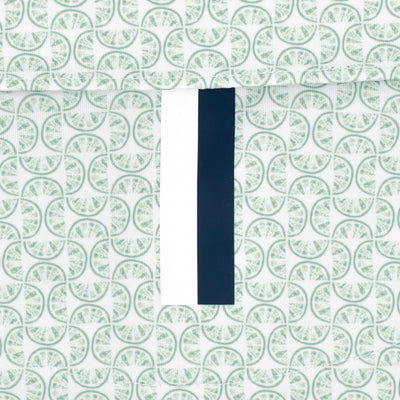The Lime | Performance Polo by RHOBACK features a patterned surface with repeating green circles and a center vertical strip—white on the left, dark blue on the right—for a crisp, moisture-wicking finish.