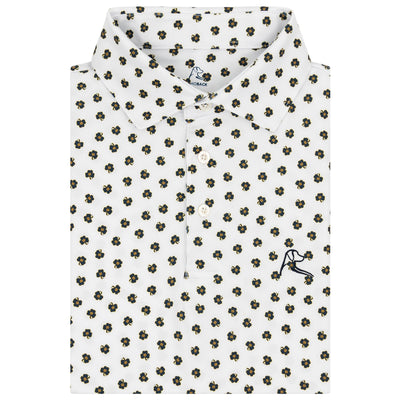 The RHOBACK Notre Dame Dancing Clover Collegiate Polo in White/Indigo Blue features a white collared design, all-over green and yellow floral print, an embroidered golfer logo, and moisture-wicking fabric for comfort.