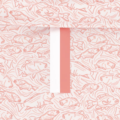 The RHOBACK Snapper Performance Polo features a breathable fabric with light pink fish line drawings on a cream background and a vertical pink and white stripe down the center.
