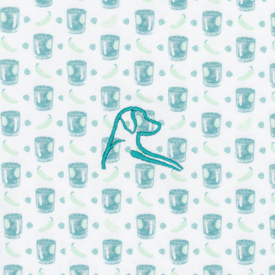 The Spicy Marg Performance Polo by RHOBACK features a breathable white and robin's egg fabric patterned with cocktail glasses, lime wedges, chili peppers, and a teal-embroidered dog’s head—perfect for a unique style.