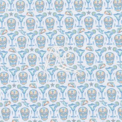 The Sugar Skull Performance Polo by RHOBACK features blue and orange skulls, martini glasses, lime wedges, and starfish on a white background with a central white embroidered logo. Offers sun protection and moisture-wicking comfort all day.