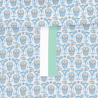 The RHOBACK Sugar Skull Performance Polo in White/Maritime Blue features a moisture-wicking fabric with blue skulls, golf icons, a central mint green and white stripe, and built-in sun protection.
